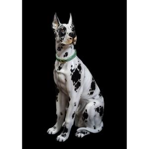 A Polychrome Porcelain Sculpture Depicting A Life-size, Seated Harlequin Great Dane.