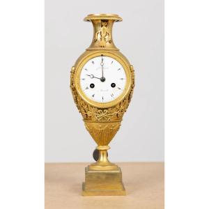 Pendule à balancier en bronze doré, ornée de feuilles et de sarments de vigne. Empire XIXème