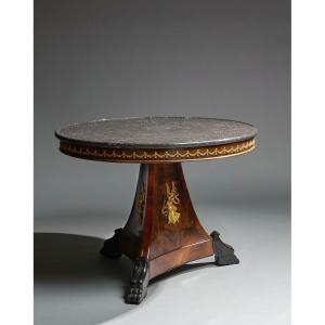 Table en placage d'acajou.  Plateau circulaire surmonté de marbre noir, XIXéme