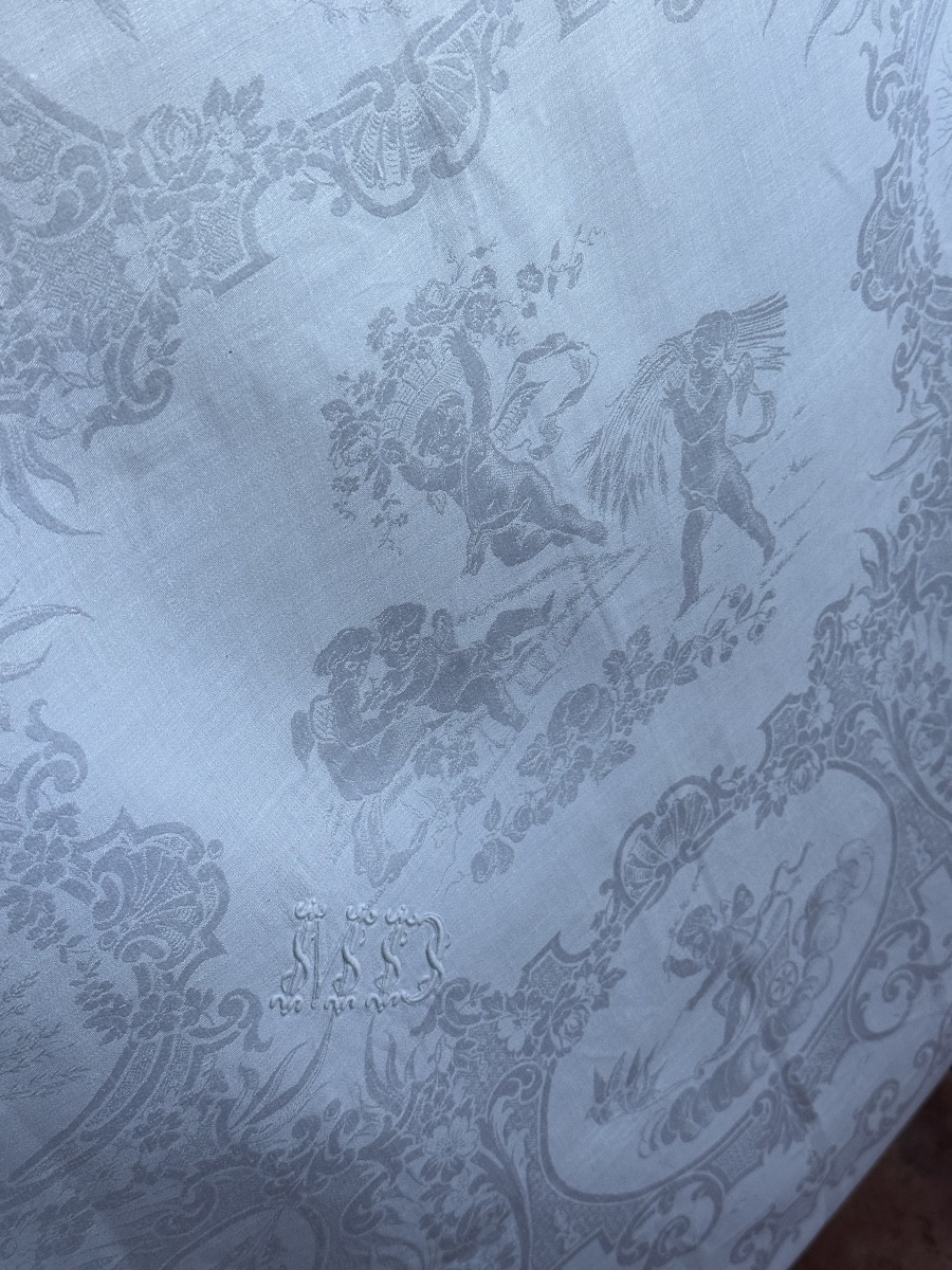 nappe ancienne 540 x 245 cm et 14 serviettes en damassé de lin et soie, décor figuratif angelot