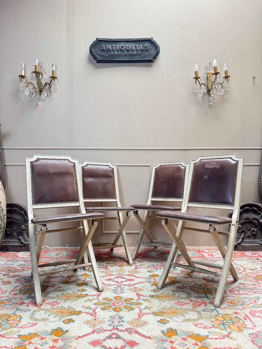 Suite de quatre chaises pliantes en bois laqué de style Louis XVI 