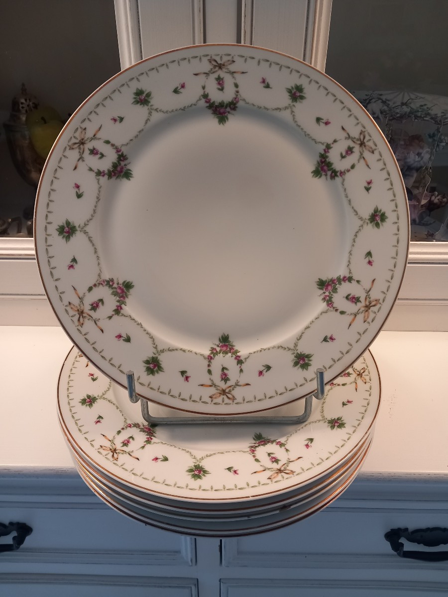 Quatre assiettes en porcelaine de Limoges haviland à guirlandes de fleurs et de rubans
