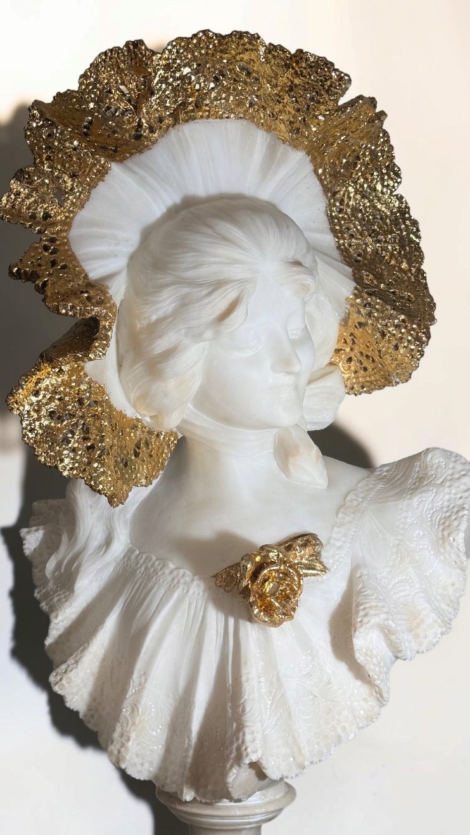 Bust Depicting A Beautiful, Smiling Young Woman Wearing A Large Hat; Marble With Gold Leaf