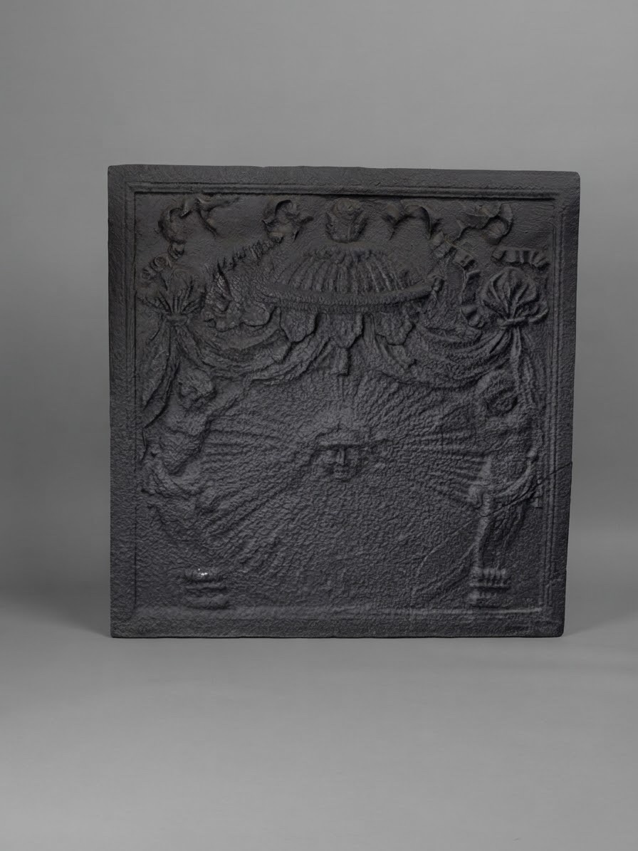 Rare plaque décorative de cheminée réalisée en fonte à décor d’un mascaron