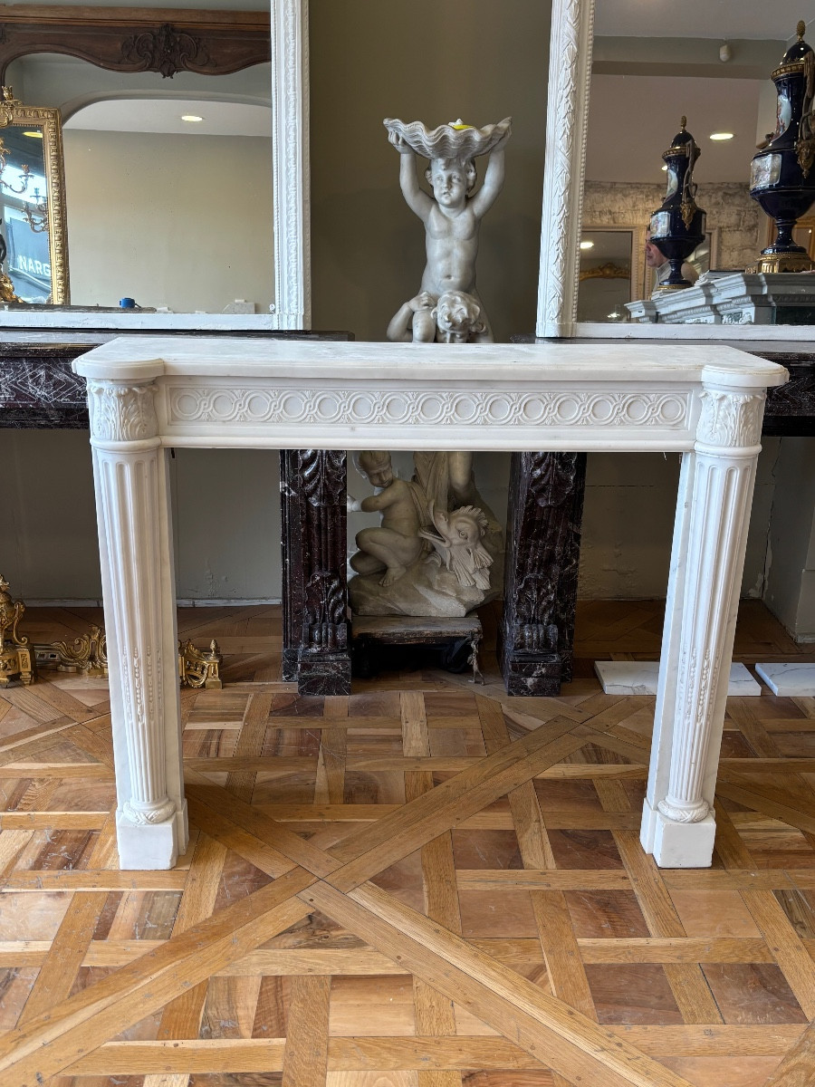 Cheminée ancienne de style Louis XVI réalisée en marbre blanc statuaire datant du XIXeme siècle