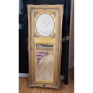 Miroir en bois doré à décor d’un médaillon 