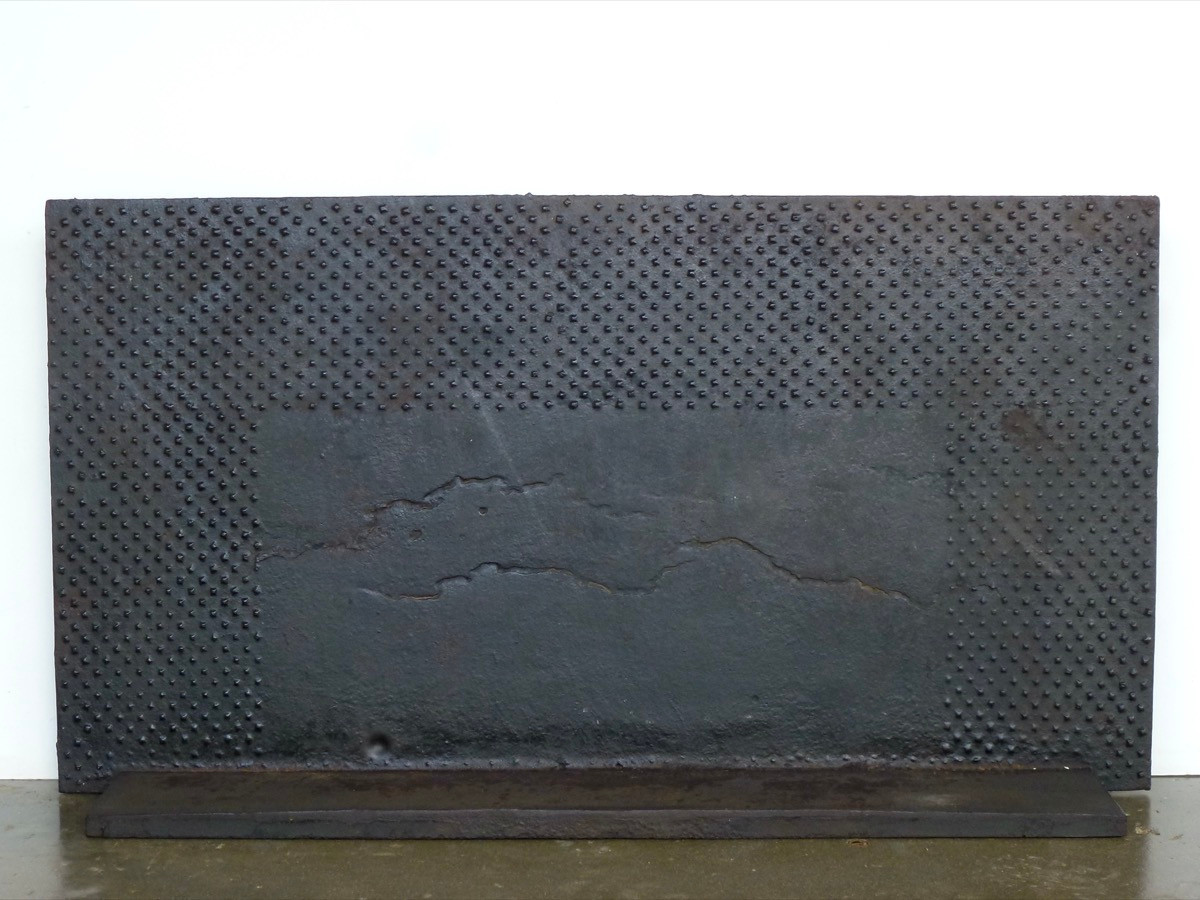 Plaque de cheminée à décor de têtes de clous forgées