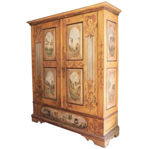 Armoire en bois peint, ornée de guirlandes et de caprices architecturaux. Marches XVIIIᵉ siècle