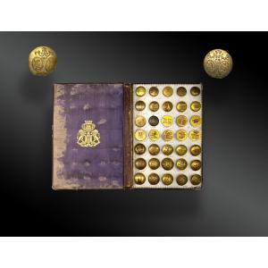 BOUTONS DE LIVRÉES ET HÉRALDIQUES SUR LIVRE PRÉSENTOIR DE LA MAISON GOURDIN ET Cie.  