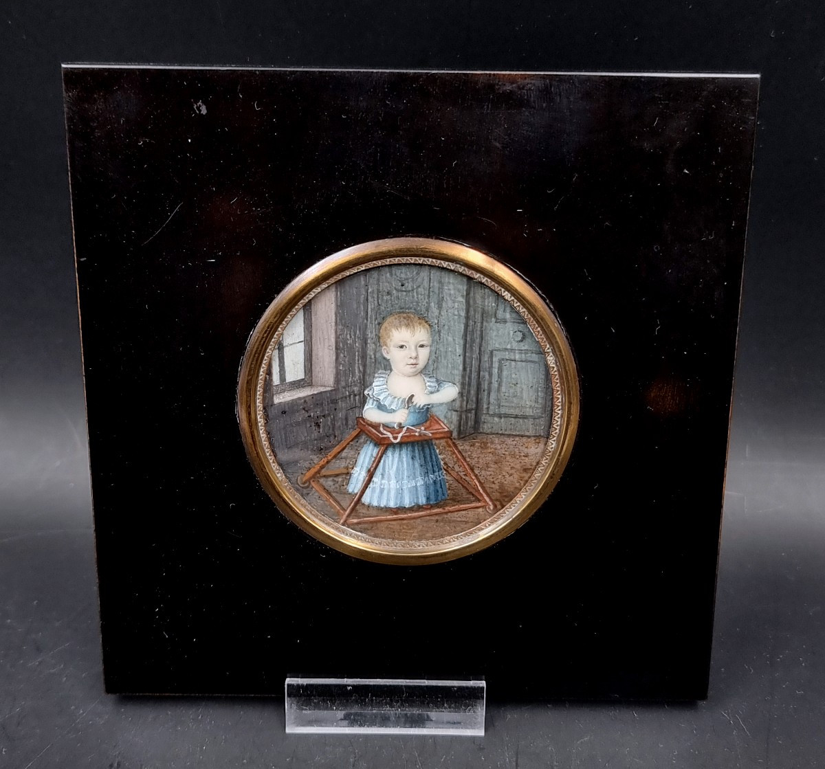 Miniature enfant jouant dans son trotteur ou youpala dans un intérieur