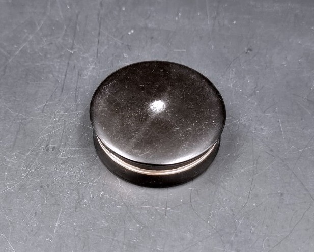 A Circular Box Made Of Composite Material, Set With A Diamond And Featuring A Gold Interior -photo-1
