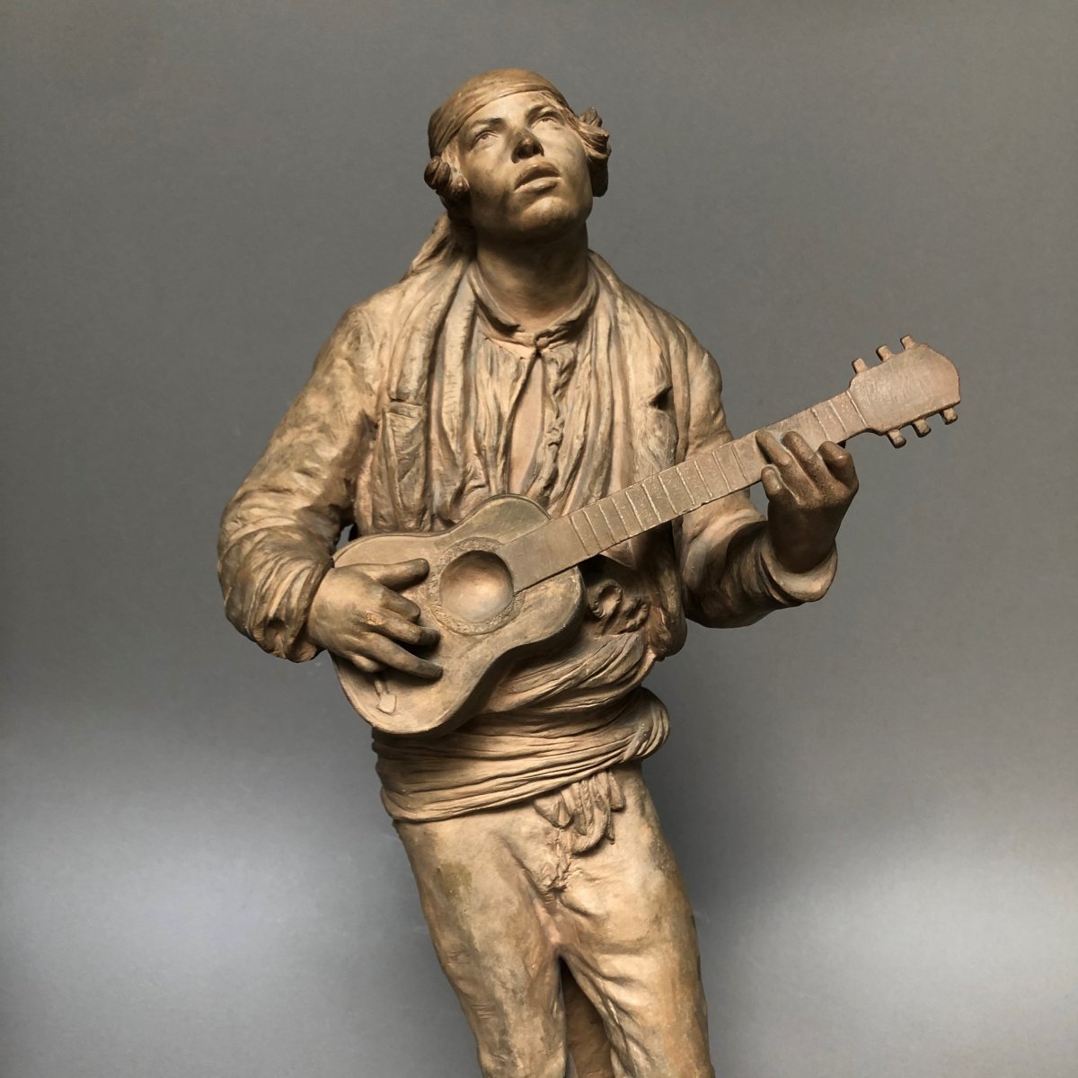 SÈVRES : Sculpture en terre cuite, jeune homme à la guitare, signé V. OMS