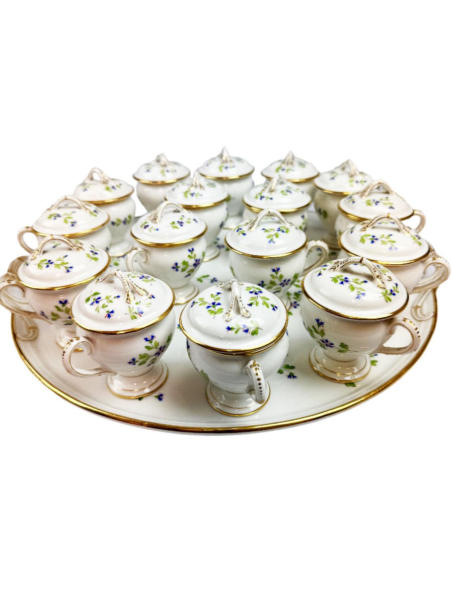 Bel ensemble composé d’un plateau et de 16 pots à crème en porcelaine, décor au barbeau