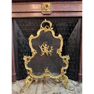 Pare feu de style Louis XV rocaille, en bronze doré,  époque XIXème, décor d’angelot