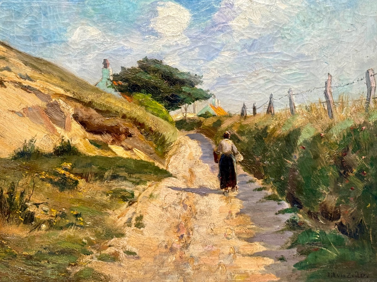 Jeune femme sur un chemin sablonneux entre les dunes 