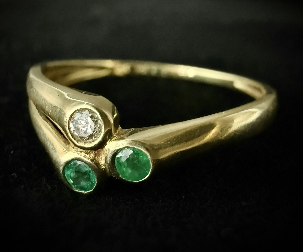 Bague or jaune sertie d'émeraudes et un brillant