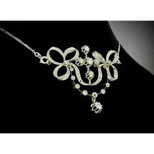 Pendentif et chaîne en platine, belle époque, noeuds de ruban et guirlandes, 1,40ct de diamants