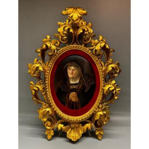 Porcelain painting in a carved and gilded wooden frame