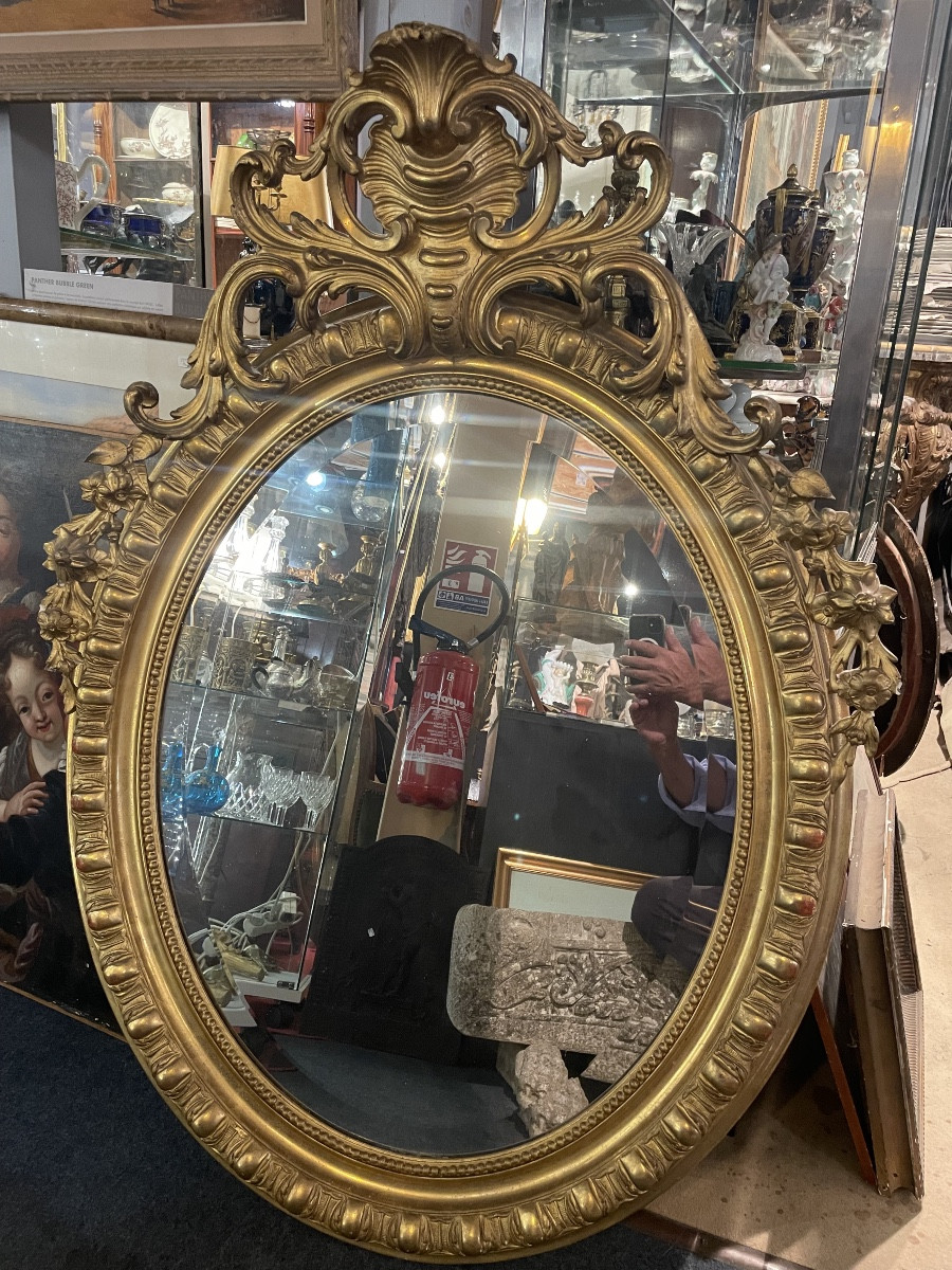 Miroir d’époque Napoléon III de forme ovale en bois doré 