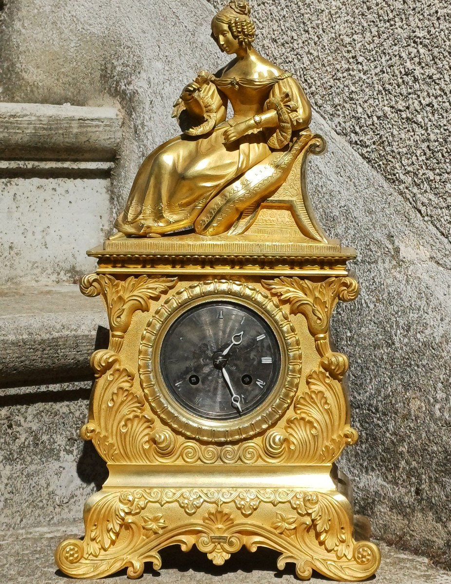 Pendule romantique à décor d'une jeune fille à la rose, bronze doré