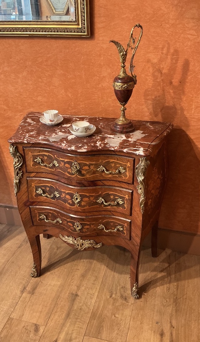 Une petite commode de style Louis XV en marqueterie.