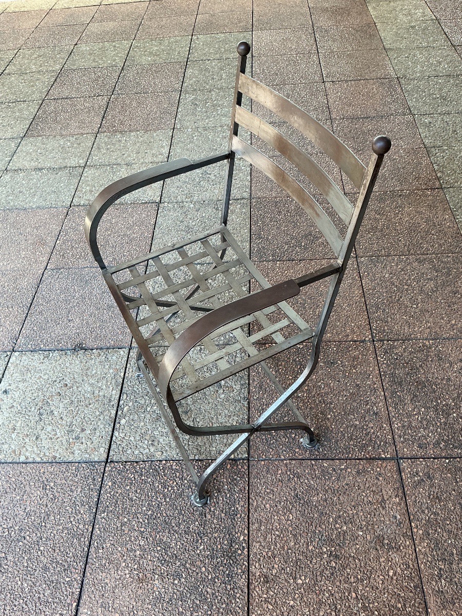 Un fauteuil curule en métal.