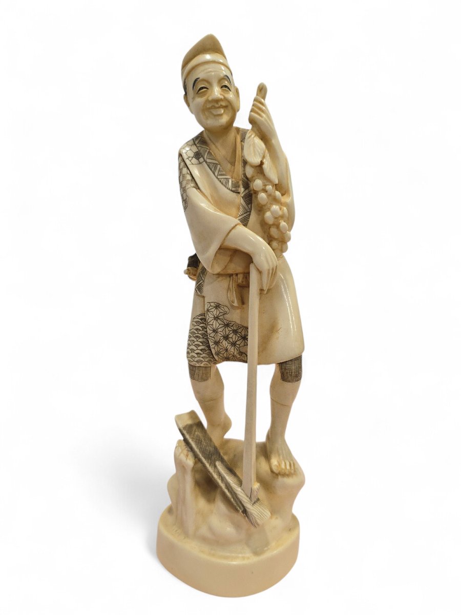Sculpture japonaise en os du XIXe siècle représentant un vendeur de raisins, signée