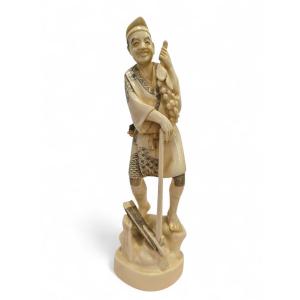 Sculpture japonaise en os du XIXe siècle représentant un vendeur de raisins, signée