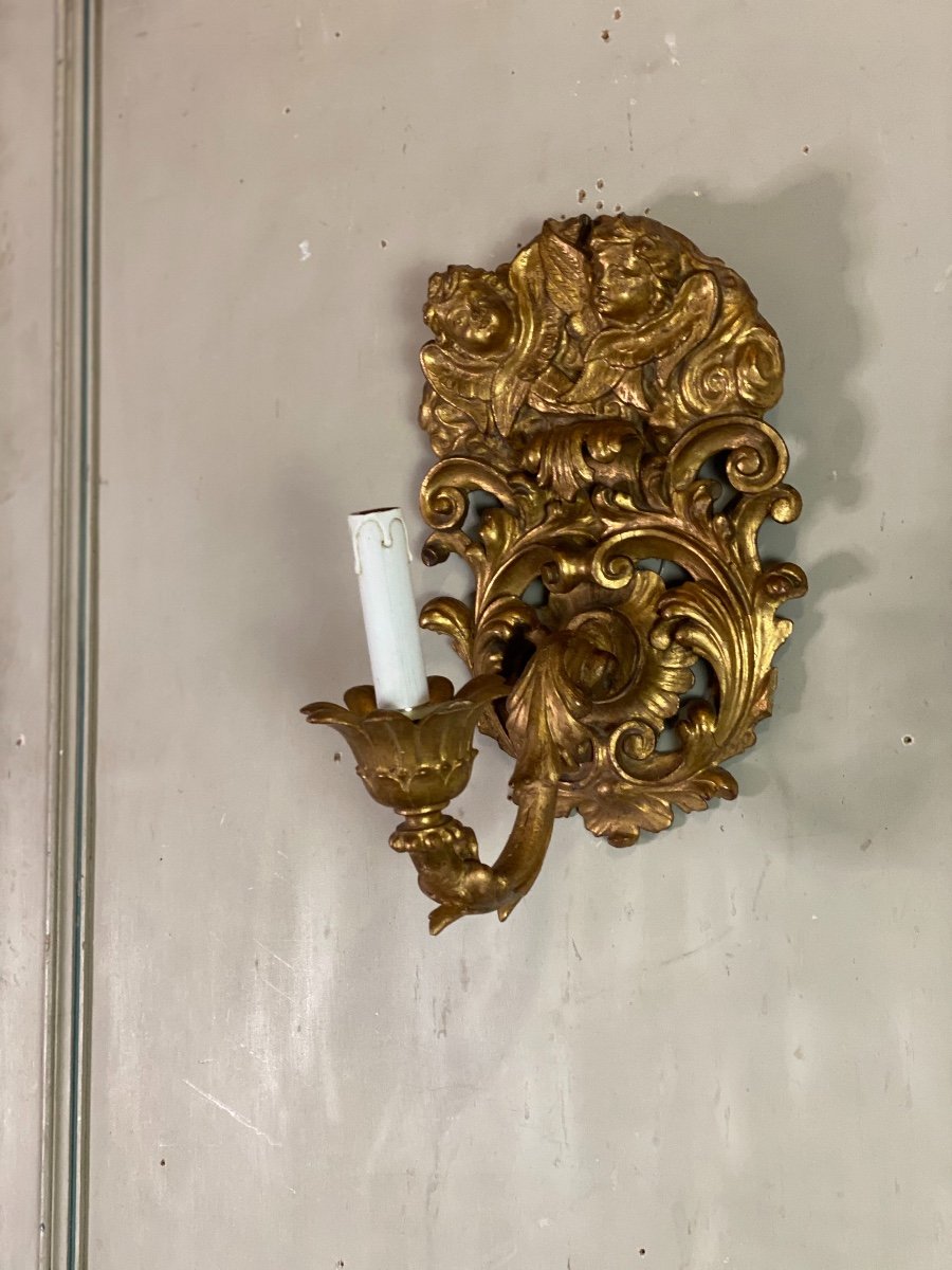 Pair Of Sconces In Carved And Gilded Wood Topped With Two Heads Of Cherubs, Italy