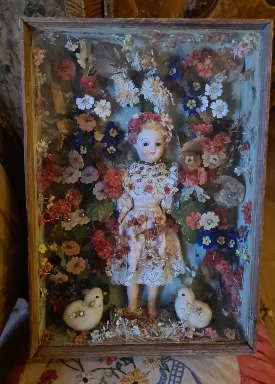 Travail de couvent avec poupée enchâssée et fleurs