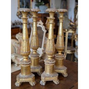 Suite de quatre bougeoirs Louis XVI en bois doré à la mecca, fin XVIIIe siècle