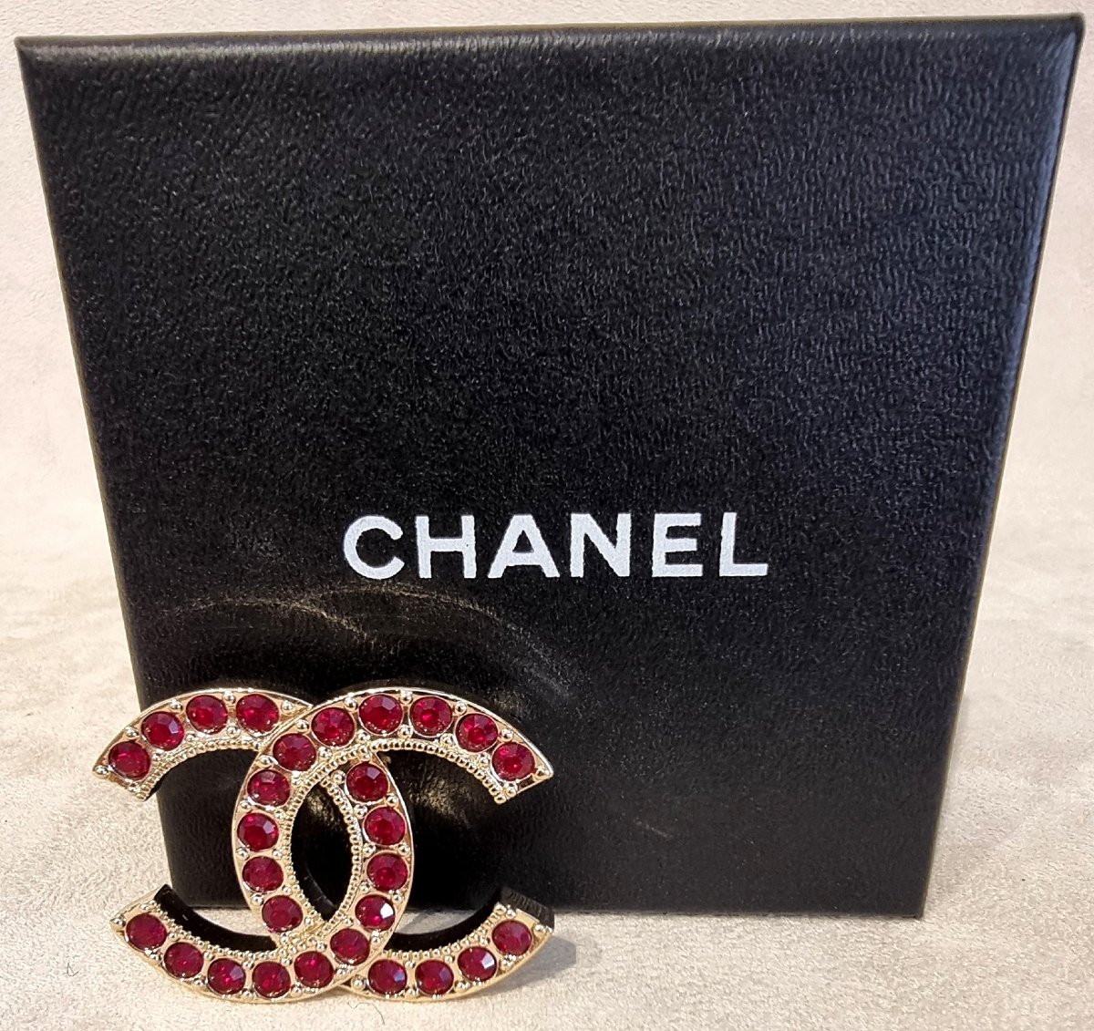 CHANEL BROCHE DOUBLE CC en métal plaqué or et cristal rouge