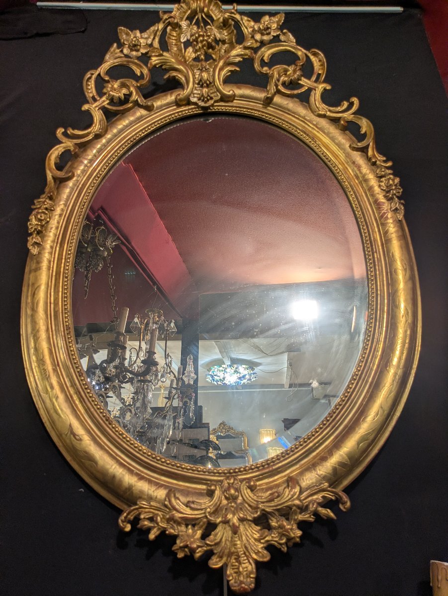 Large Oval Gilded Mirror With A Floral And Vine-decorated Pediment; Napoleon III Style, Late 19th Century