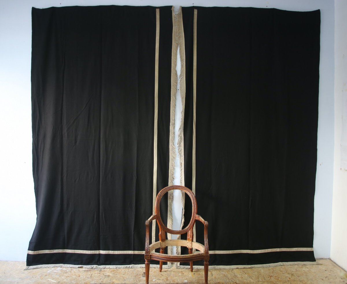Grande paire de doubles rideaux en drap de laine noirs et passementerie argentée.