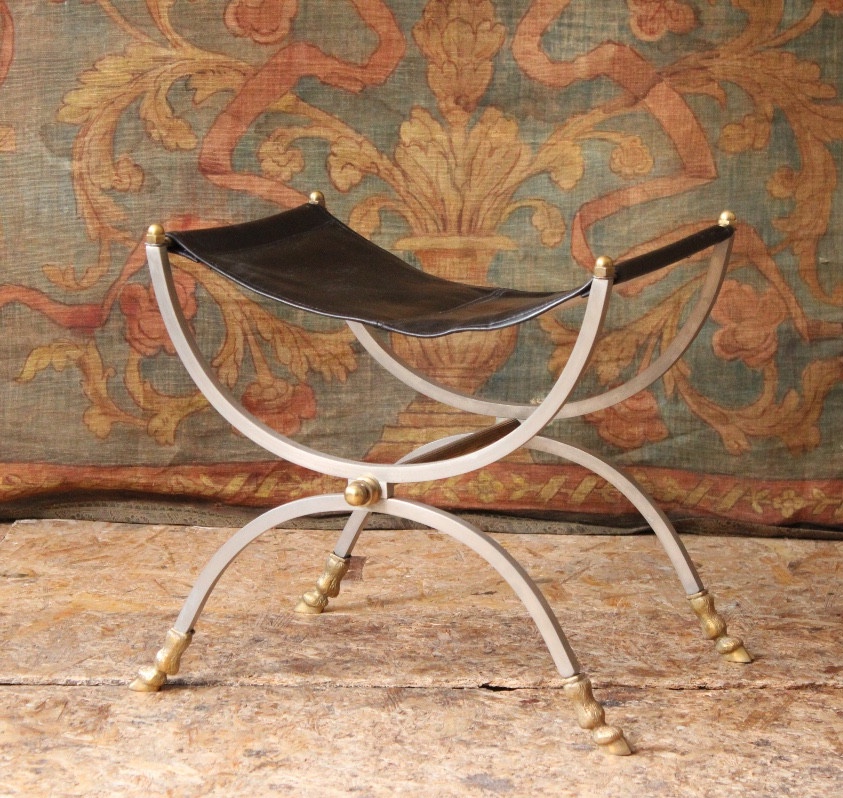 Siège tabouret curule en fer forgé poli et ornementations en laiton, XXe siècle