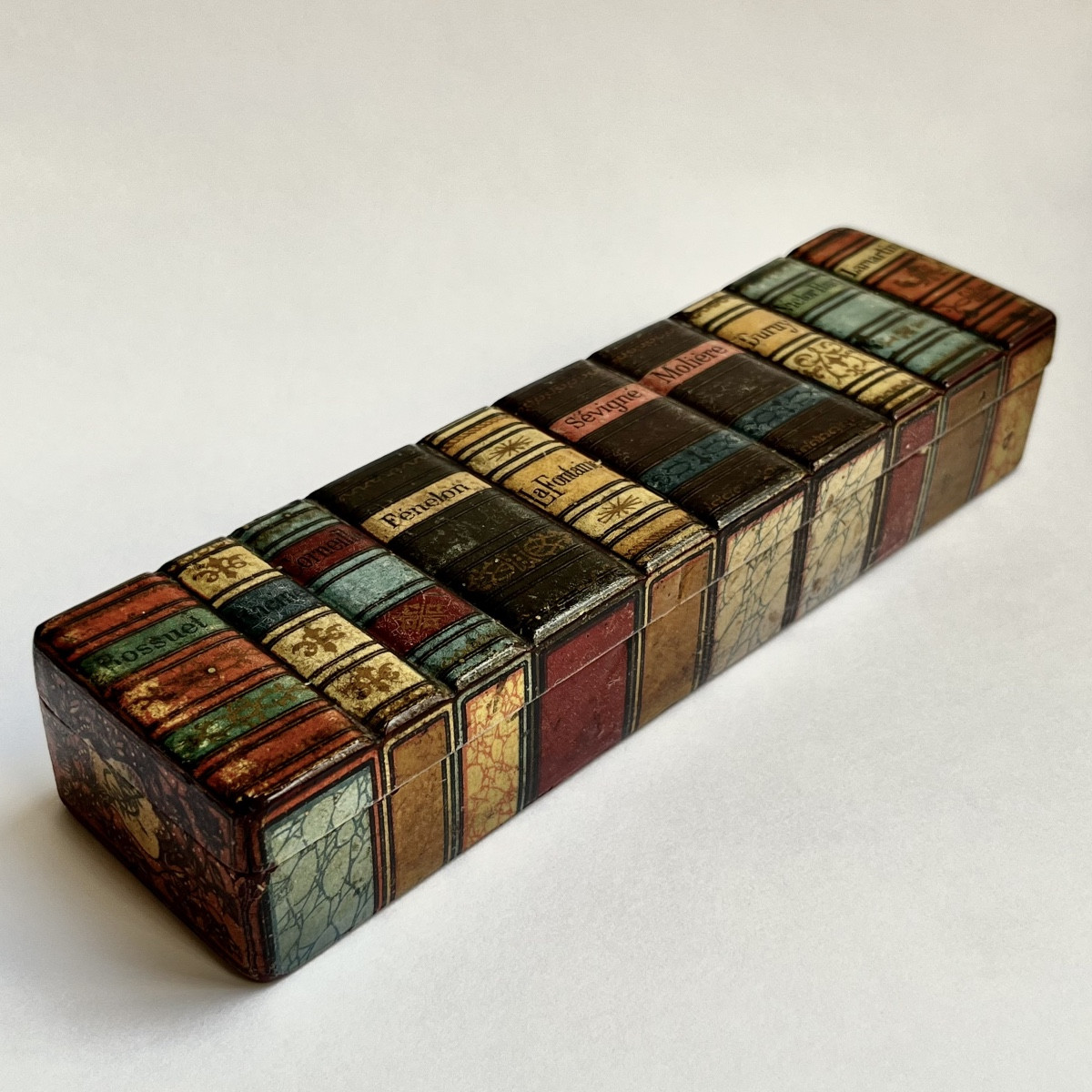 Plumier en papier mâché à décor d'un trompe l'oeil de livres en relief fin XIXe - début XXe