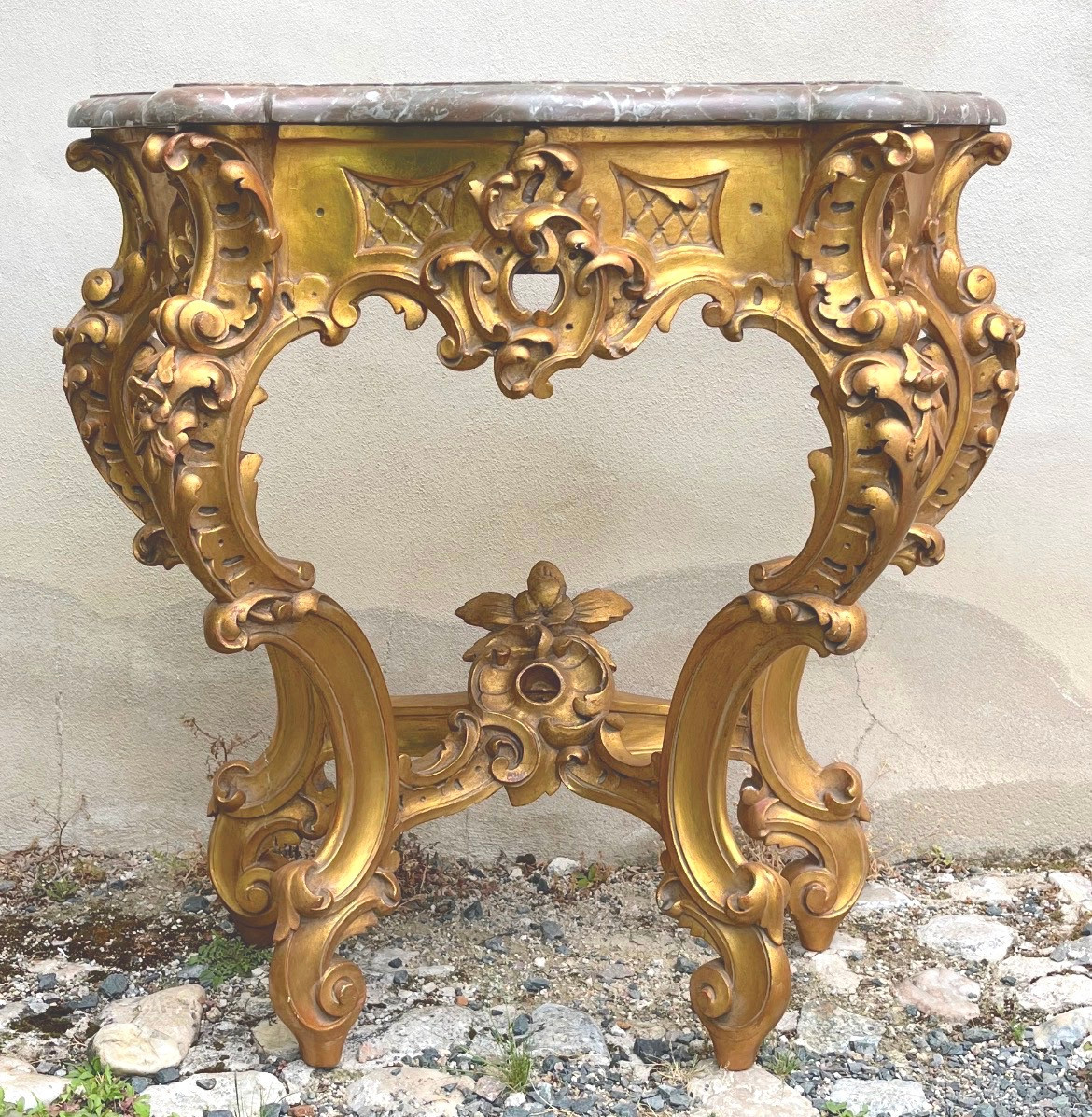 Console en bois doré et dessus marbre brun rouge de style Louis XV rocaille. Fin XIXe siècle.