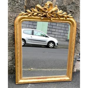 Miroir, glace en stuc doré à fronton à décor de carquois et de végétaux. Milieu XIXe siècle.  