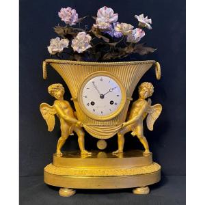 Pendule aux 2 Amours en bronze doré et fleurs de porcelaine.