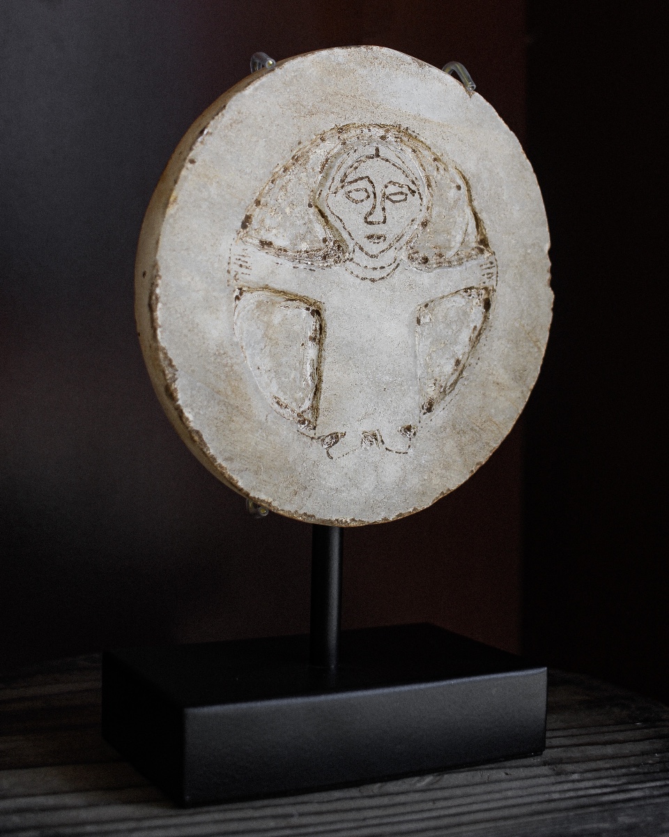 Rondelle en marbre brut du début du Moyen Âge représentant une figure orante sur un support