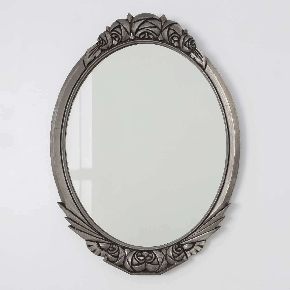 Miroir ovale Art Déco français, années 1920, orné de roses sculptées et d'un cadre argenté.