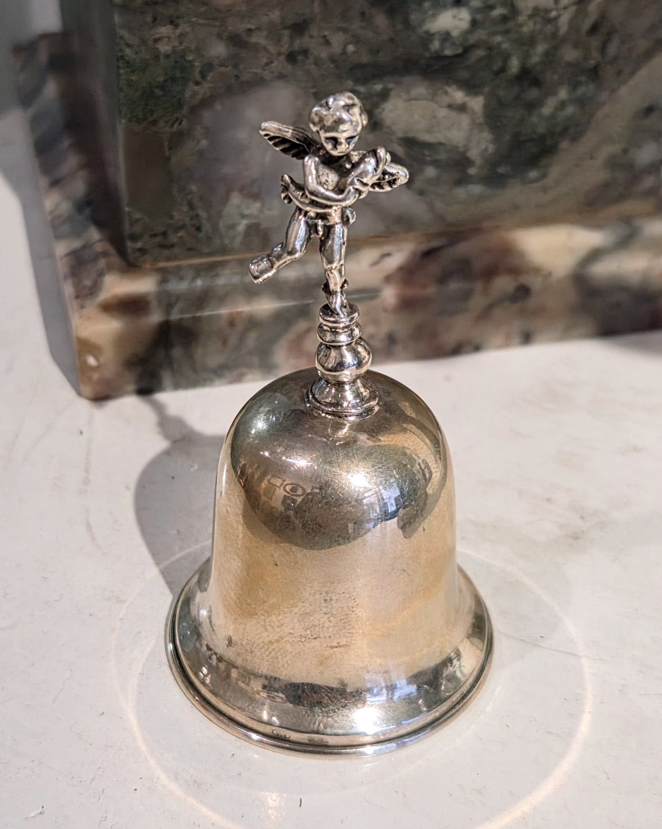 Cloche de table en argent ornée d'un chérubin et d'un triton.