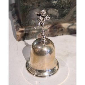 Cloche de table en argent ornée d'un chérubin et d'un triton.
