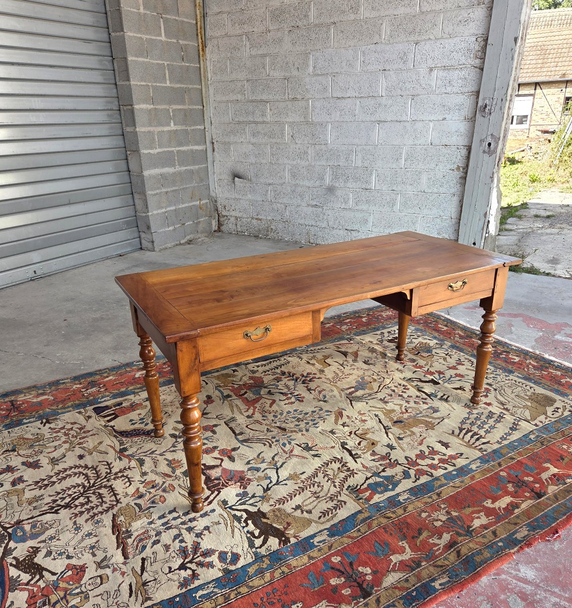 Bureau de milieu en merisier blond. Époque Louis-Philippe, XIXᵉ siècle.