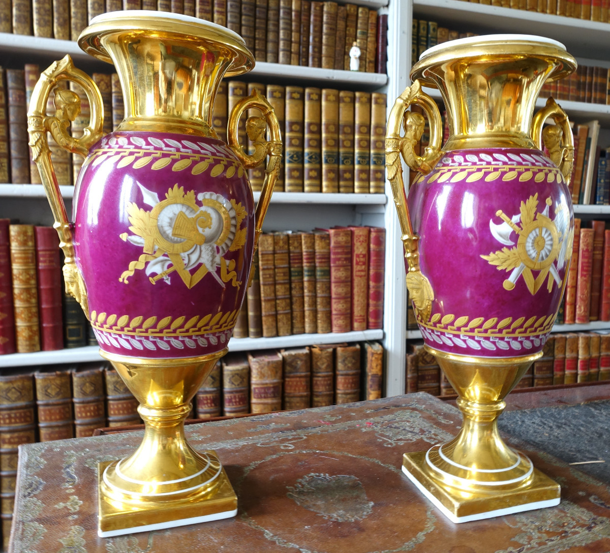 Paire de vases en porcelaine de Paris dorée et polychrome à trophées militaires d'époque Empire