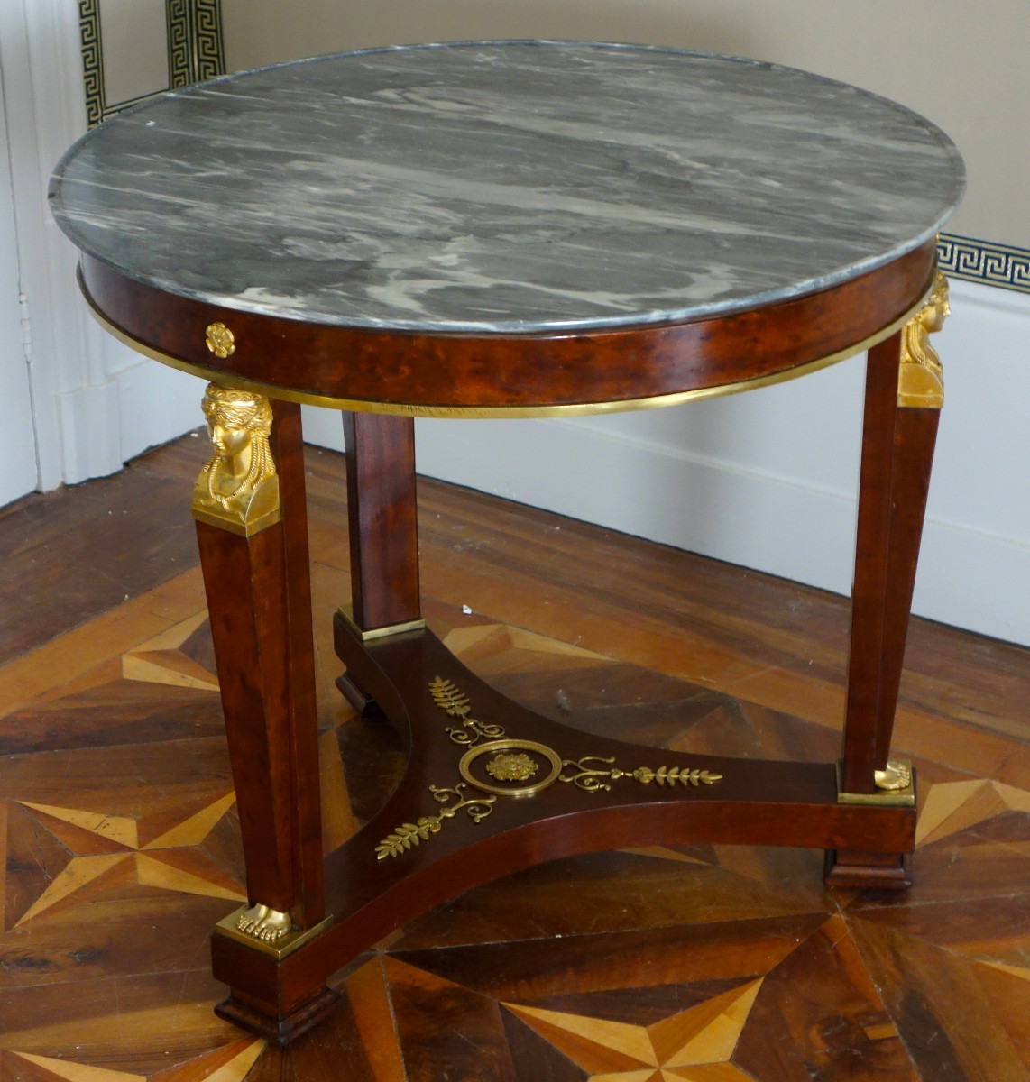 A Mahogany Pedestal Table From The Consulate/empire Period, With Rich Gilt Bronze Mounts And A Turquin Marble Top.