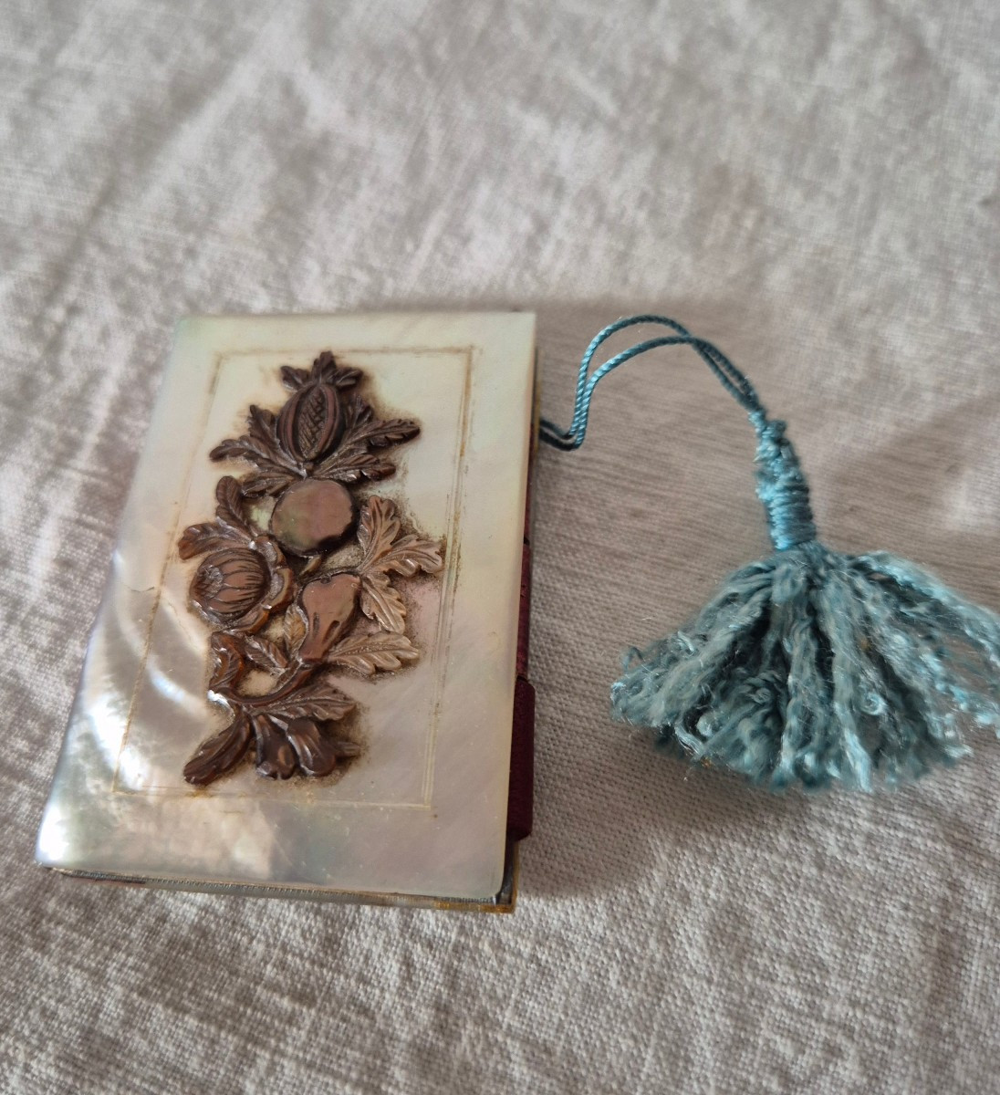 Tout petit carnet de bal souvenir en nacre clair et décor sculpté foncé du XIXème siècle 