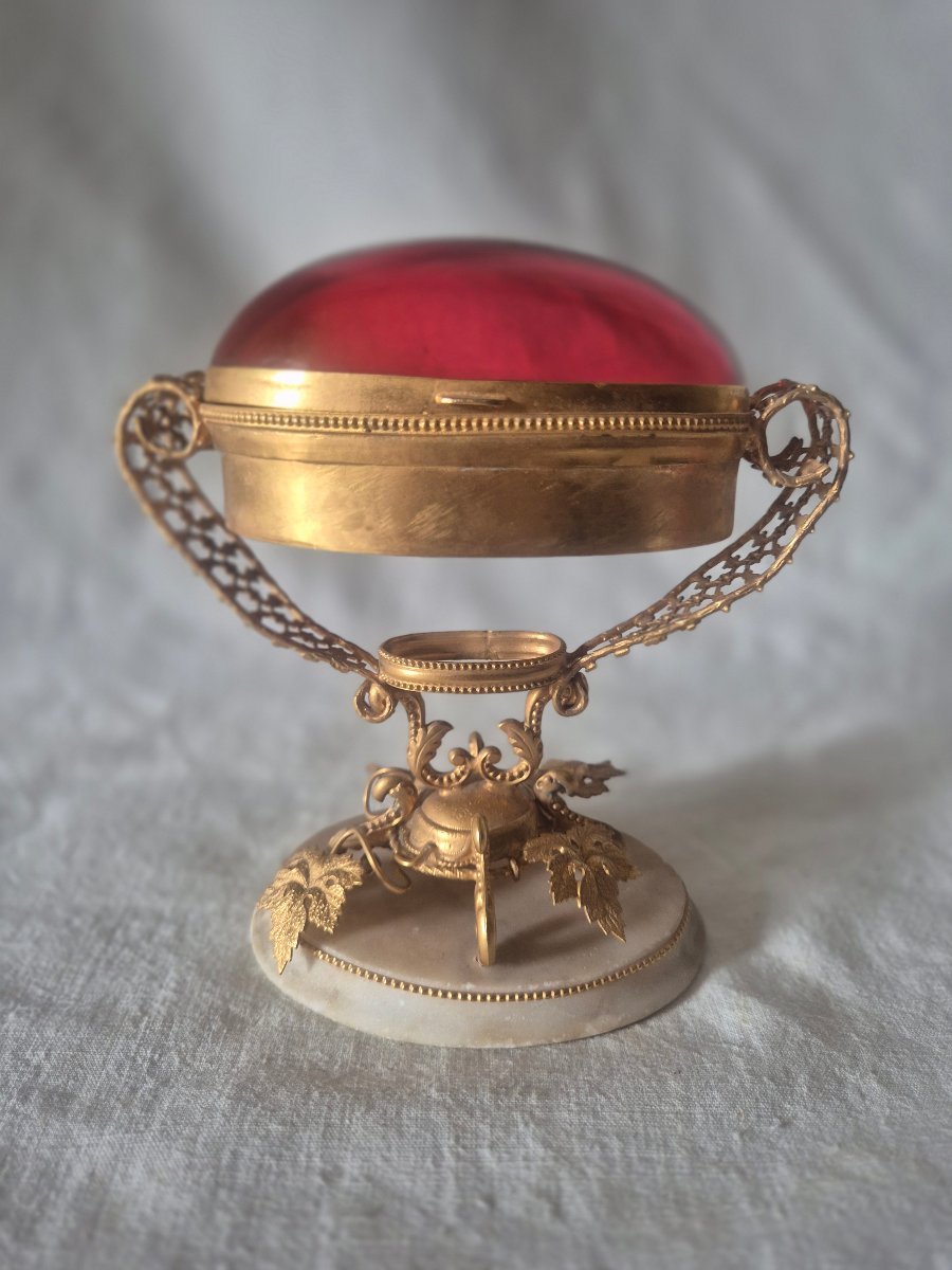 Boîte à bijoux et des petits riens en bronze pomponne doré et verre rouge ovale de forme ovée
