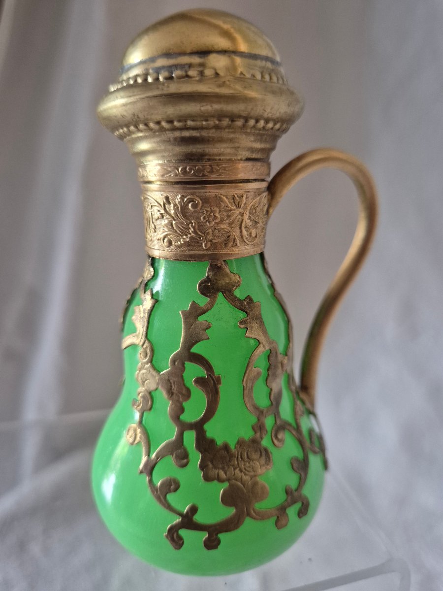 Flacon de parfum en opaline verte et habillé d’une dentelle de pomponne doré 