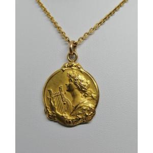 Pendentif en plaqué or, jeune femme à la lyre, signé Becker, Art Nouveau vers 1900.